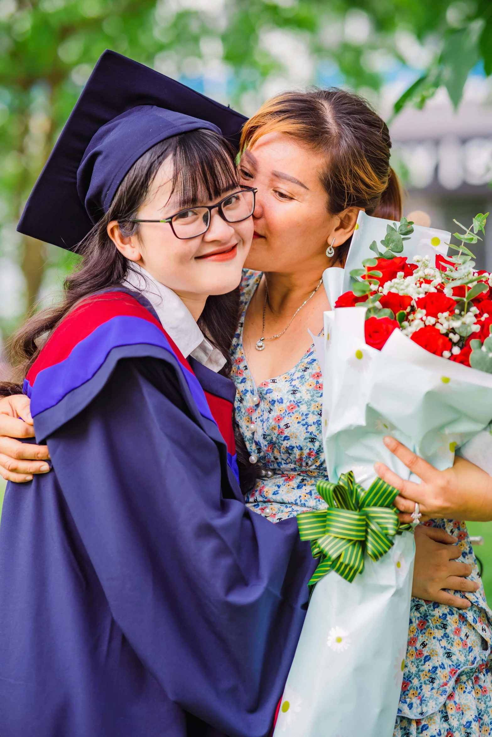 two girls are standing with flowers and a diploma