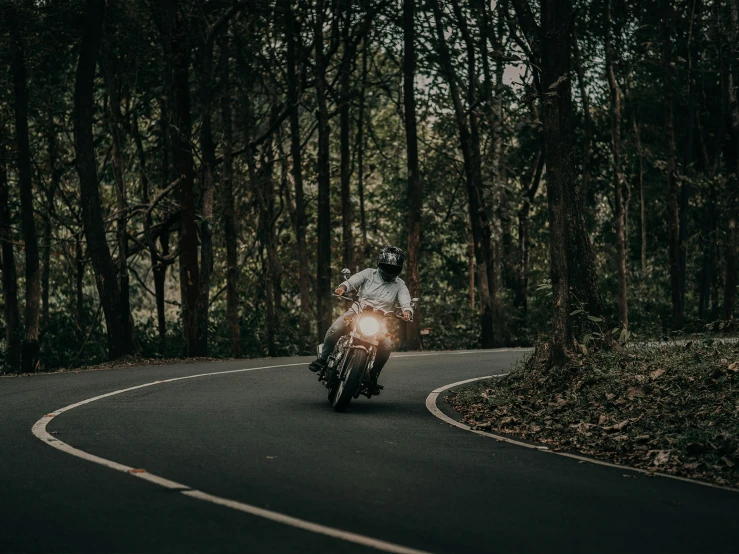 a man riding a motorcycle on a winding road