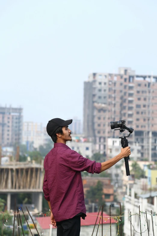 a man holding a camera on top of a roof
