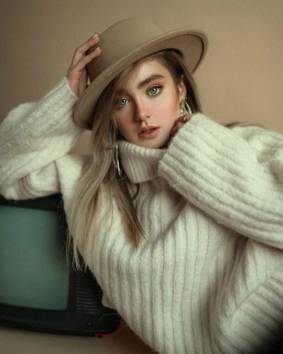 a woman wearing a white sweater and hat