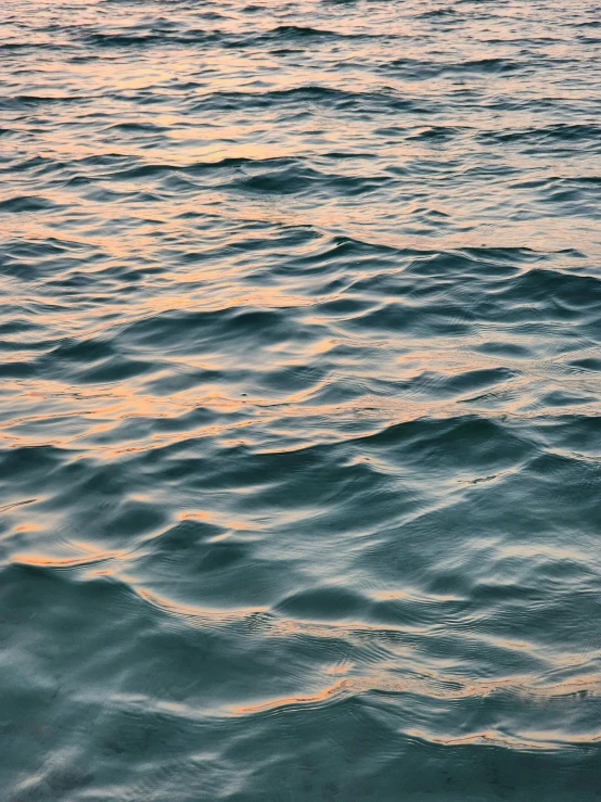 an ocean filled with water and waves at sunset