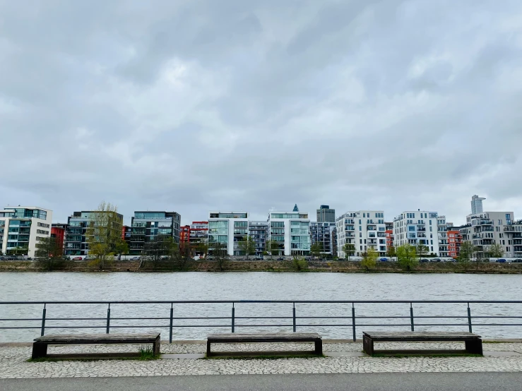 four park benches and a railing overlooking a large river