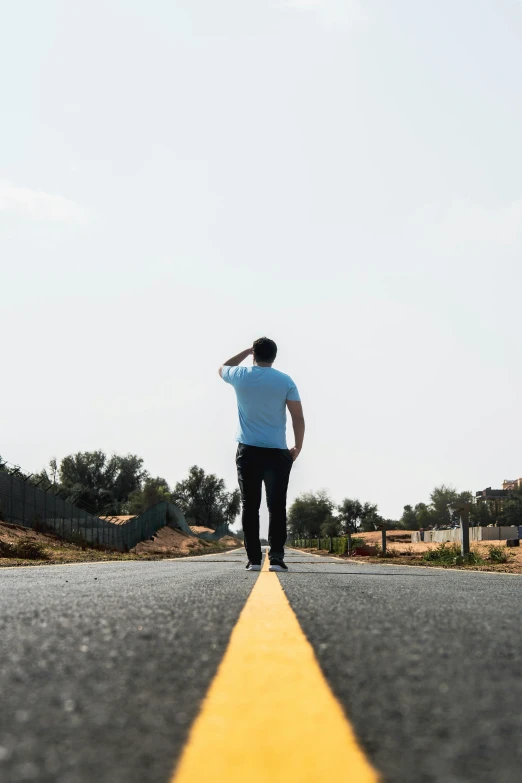 a man stands on the road as he looks ahead