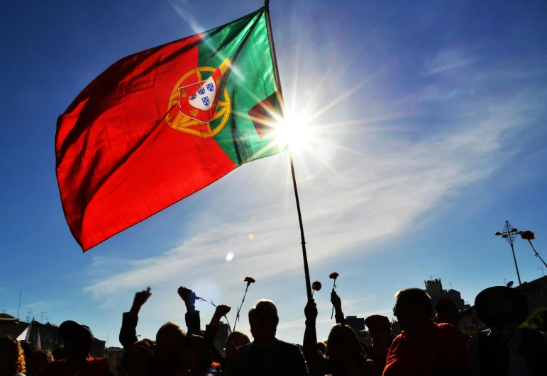 a group of people with a large flag in the background