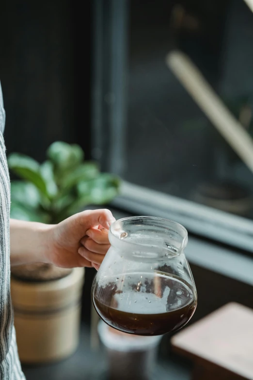 a person that is pouring some water in a jug