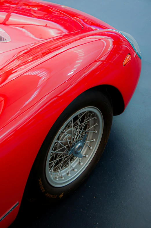 a red sports car with chrome spokes and chrome rims