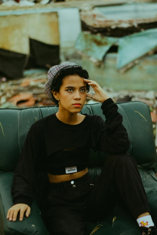 young woman sitting on green couch in urban setting