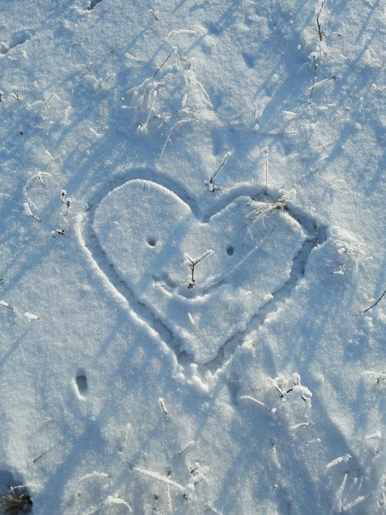 a heart shaped in the snow on top of the ground