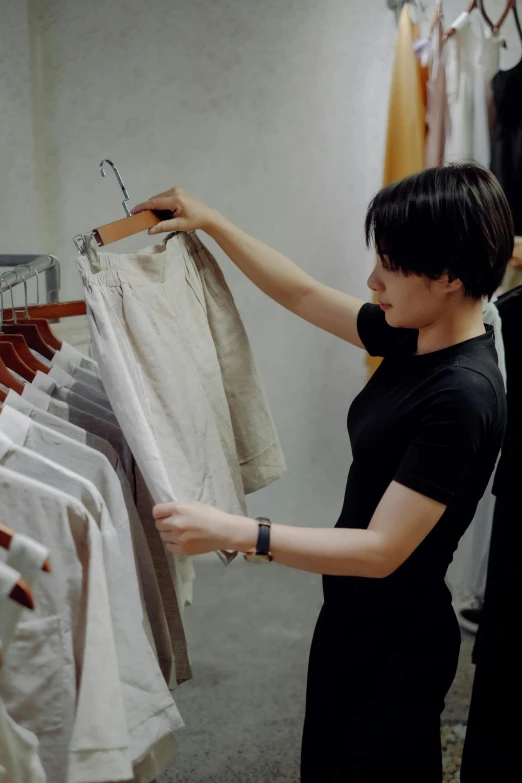 a woman holding on to a clothes rail with an order hanging