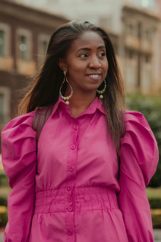 a woman with long hair wearing a pink dress