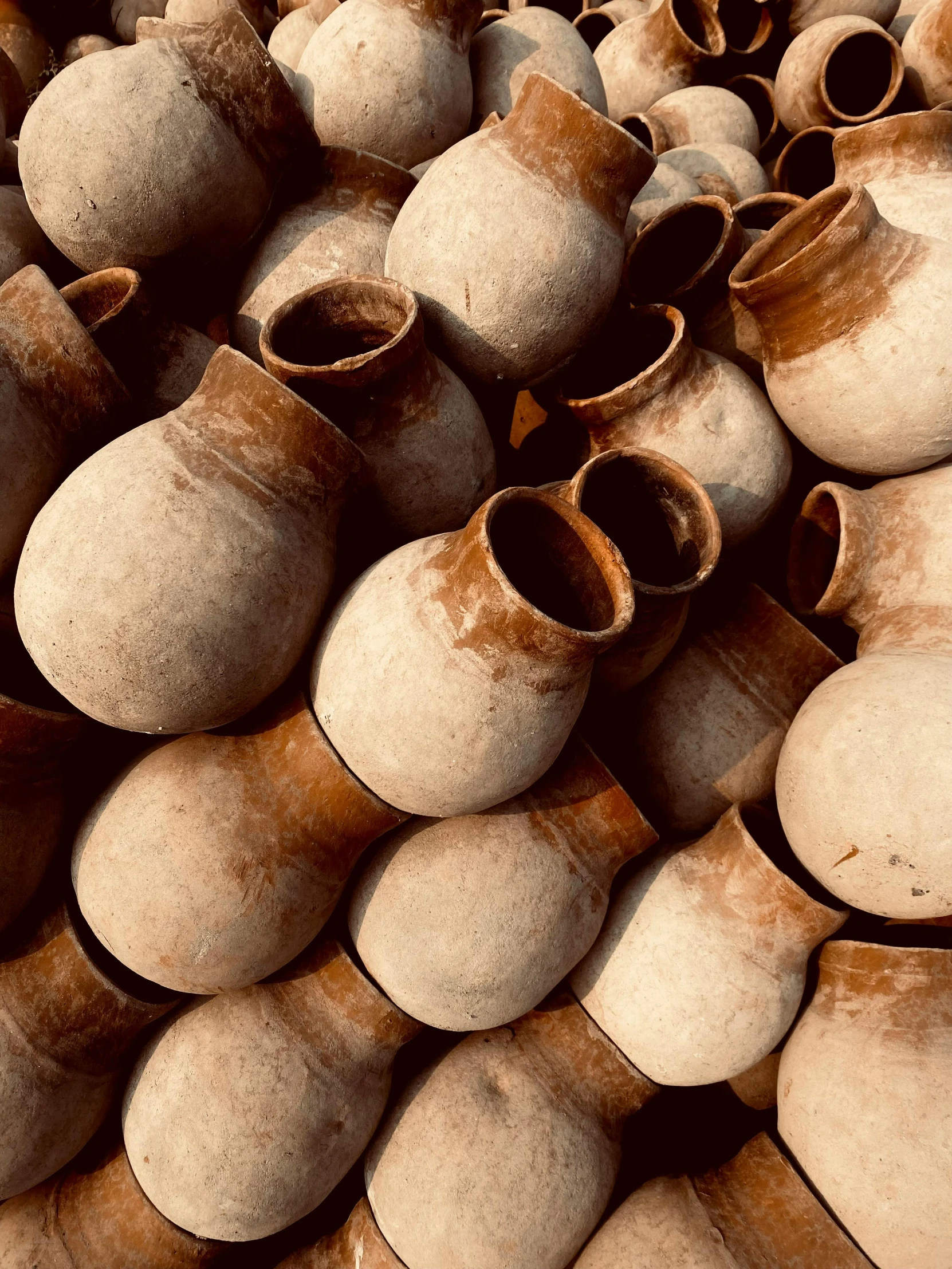 a lot of clay pot's sit together on the floor