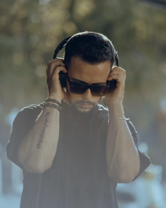 a man in black shirt holding up headphones