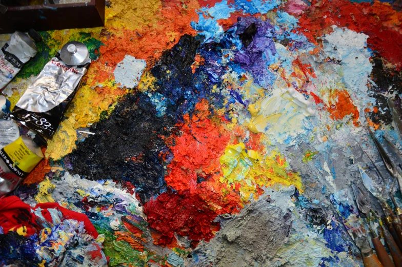 a palette of paint and paints next to a brush