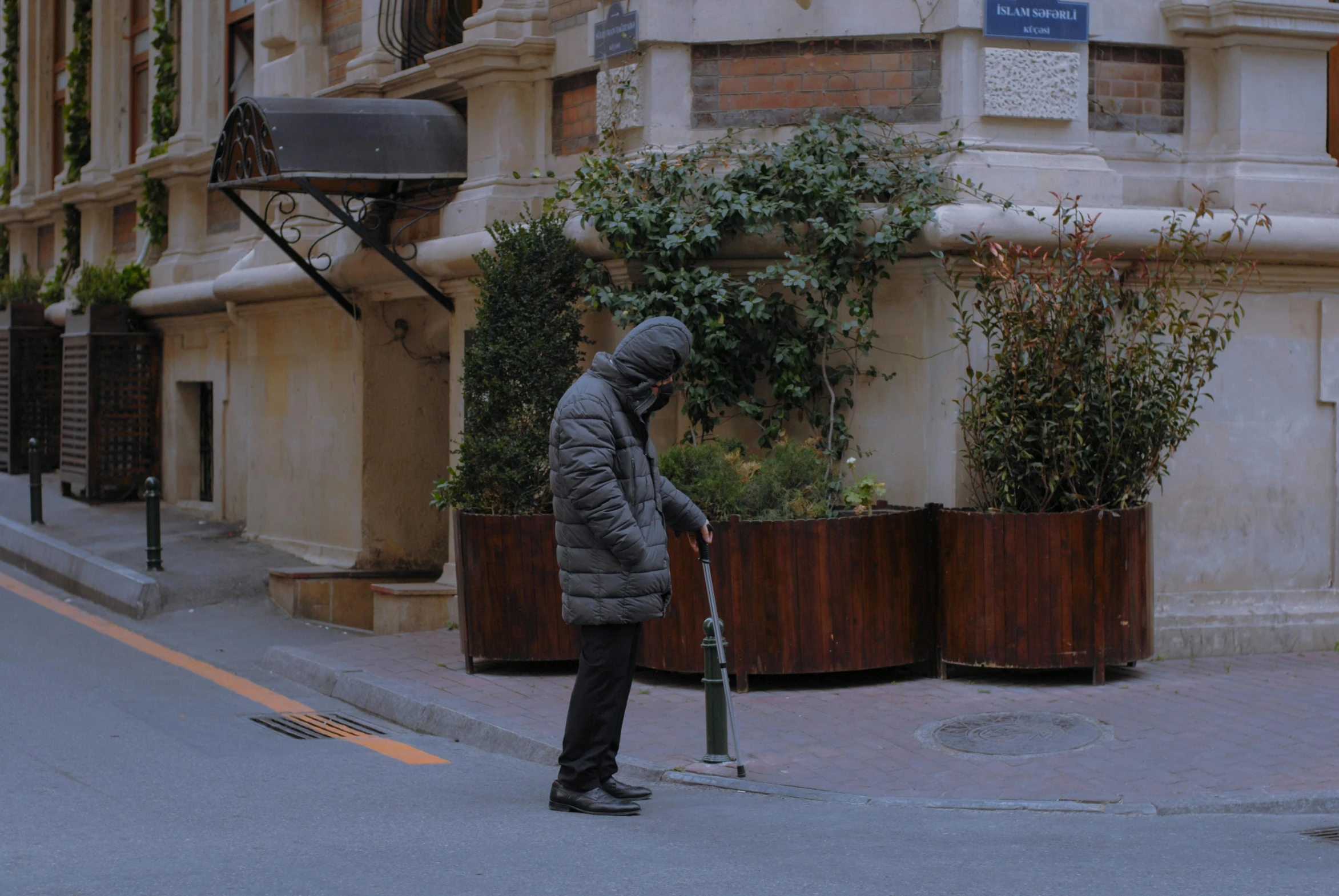 a man that is standing on the street holding a brush