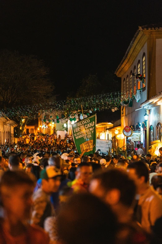 the crowd is full as people walk through a street