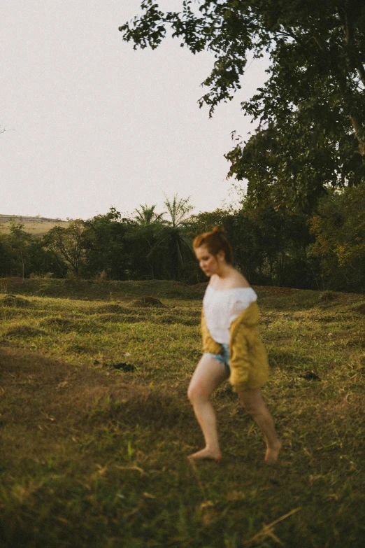 a young man is playing frisbee on a hill