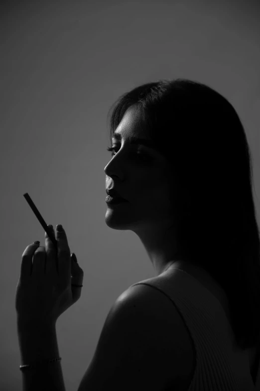 black and white pograph of woman holding out cigarette