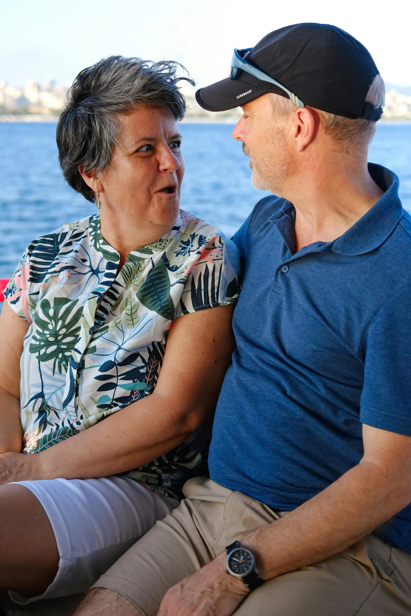 man and woman sitting on a boat looking at each other