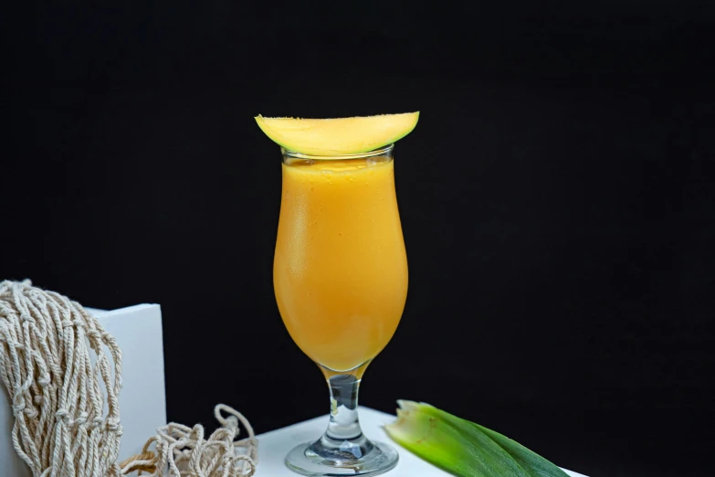 an orange drink sitting on top of a white table