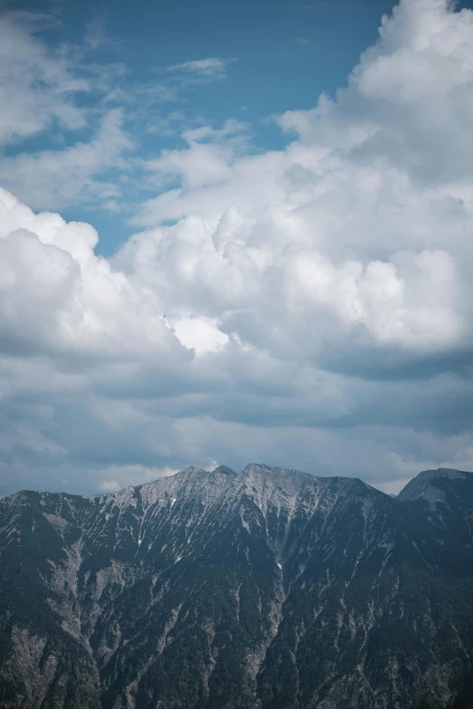 two mountains are next to each other under a cloudy sky