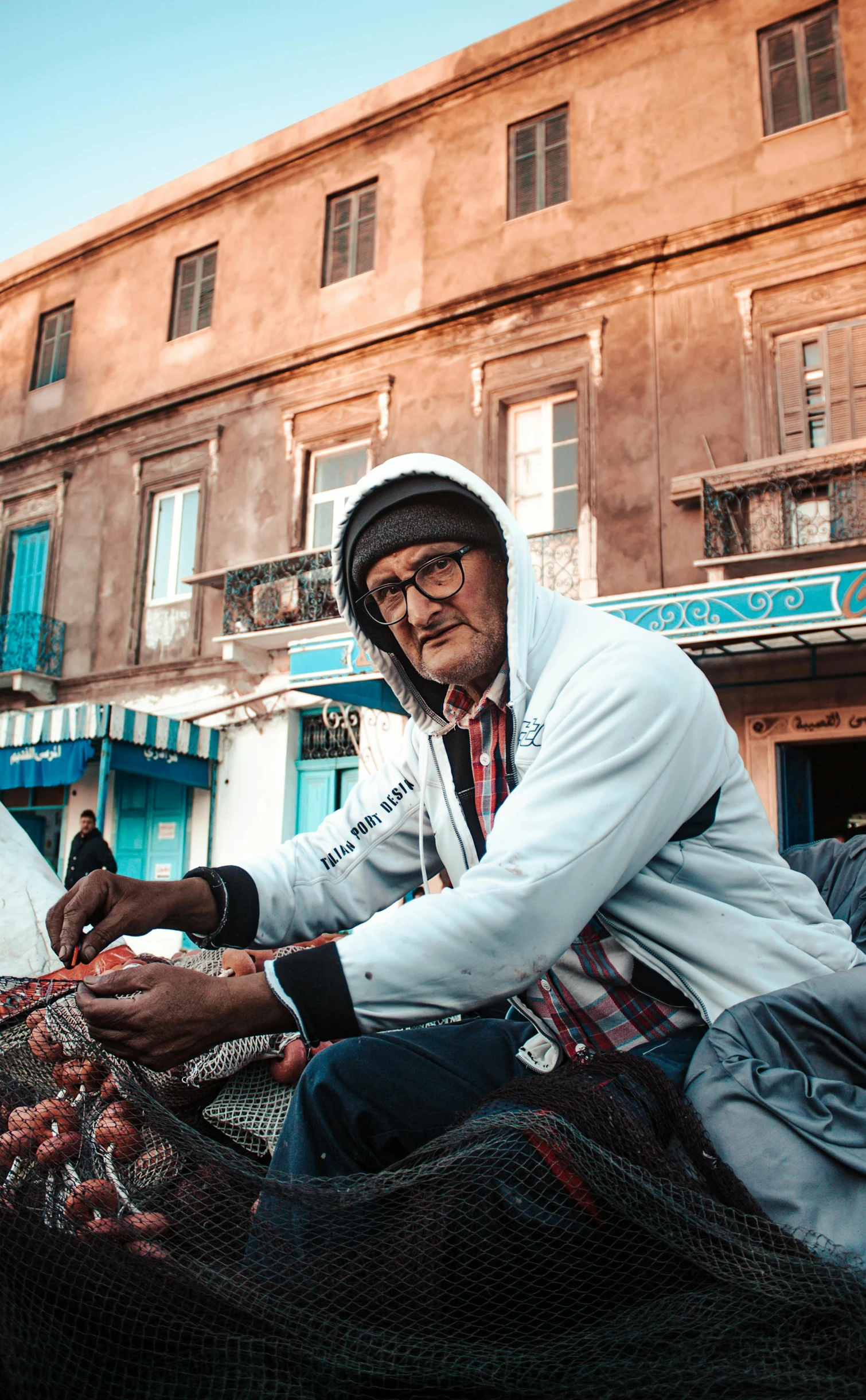 a man who is sitting outside selling tomatoes