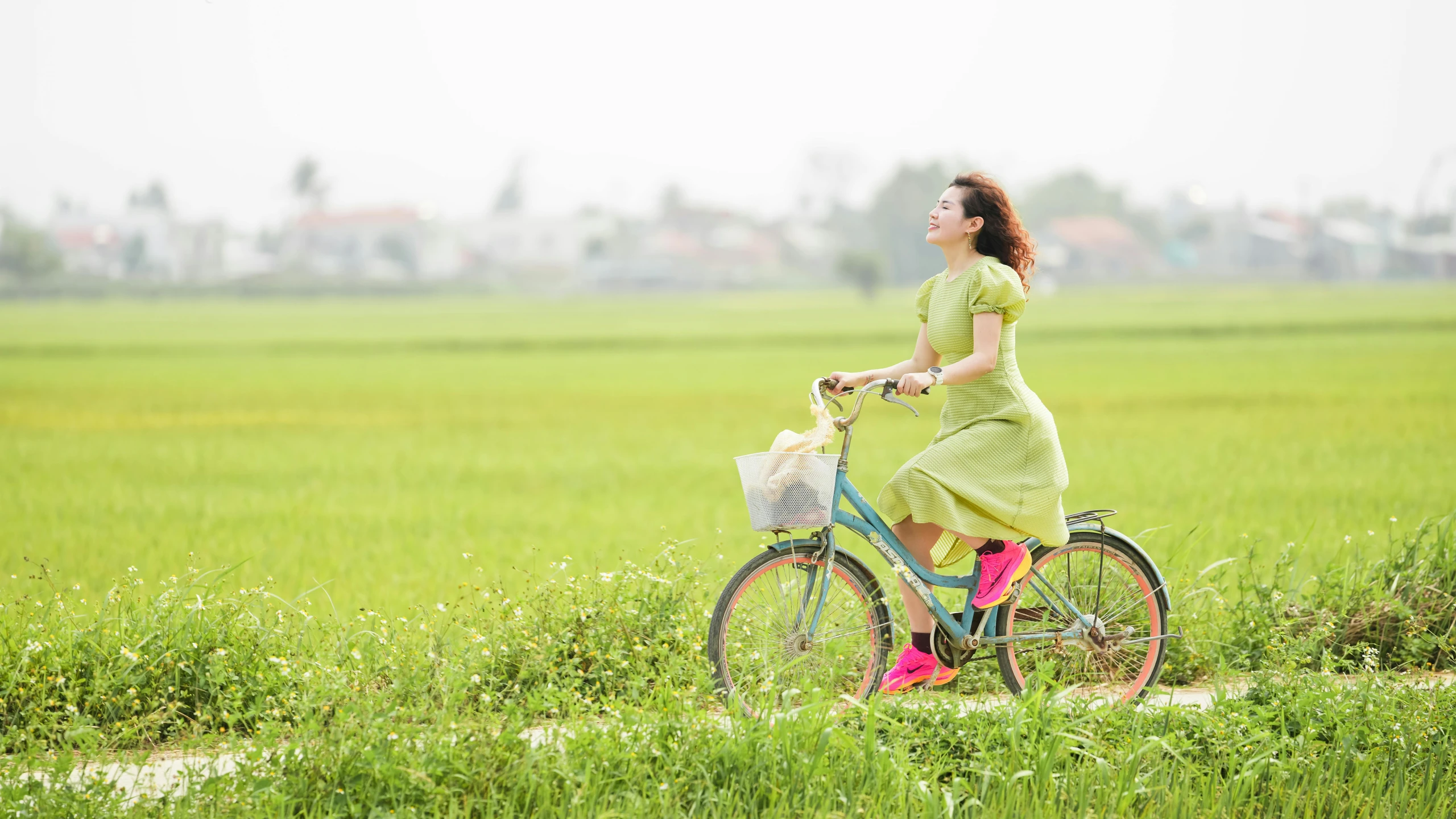 a woman in green is riding a bike