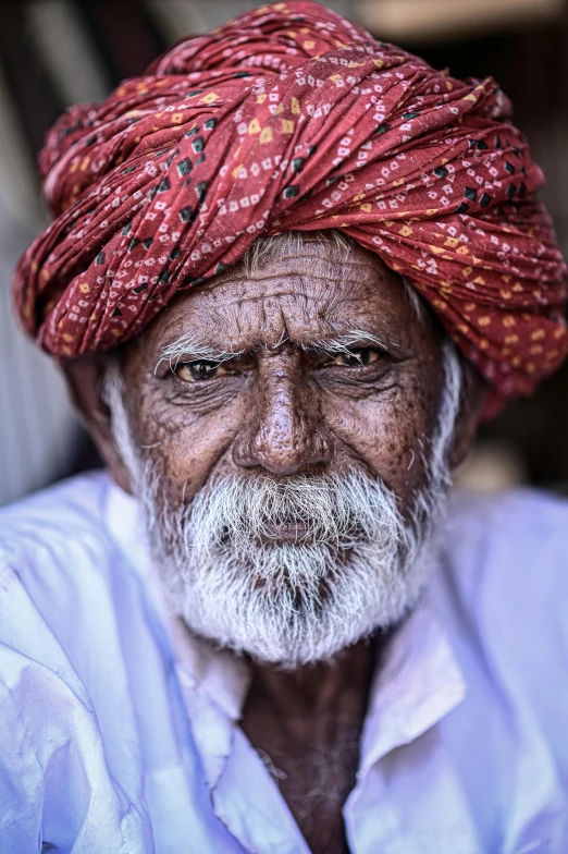 a man with white beard and turban, with blue shirt and white shirt