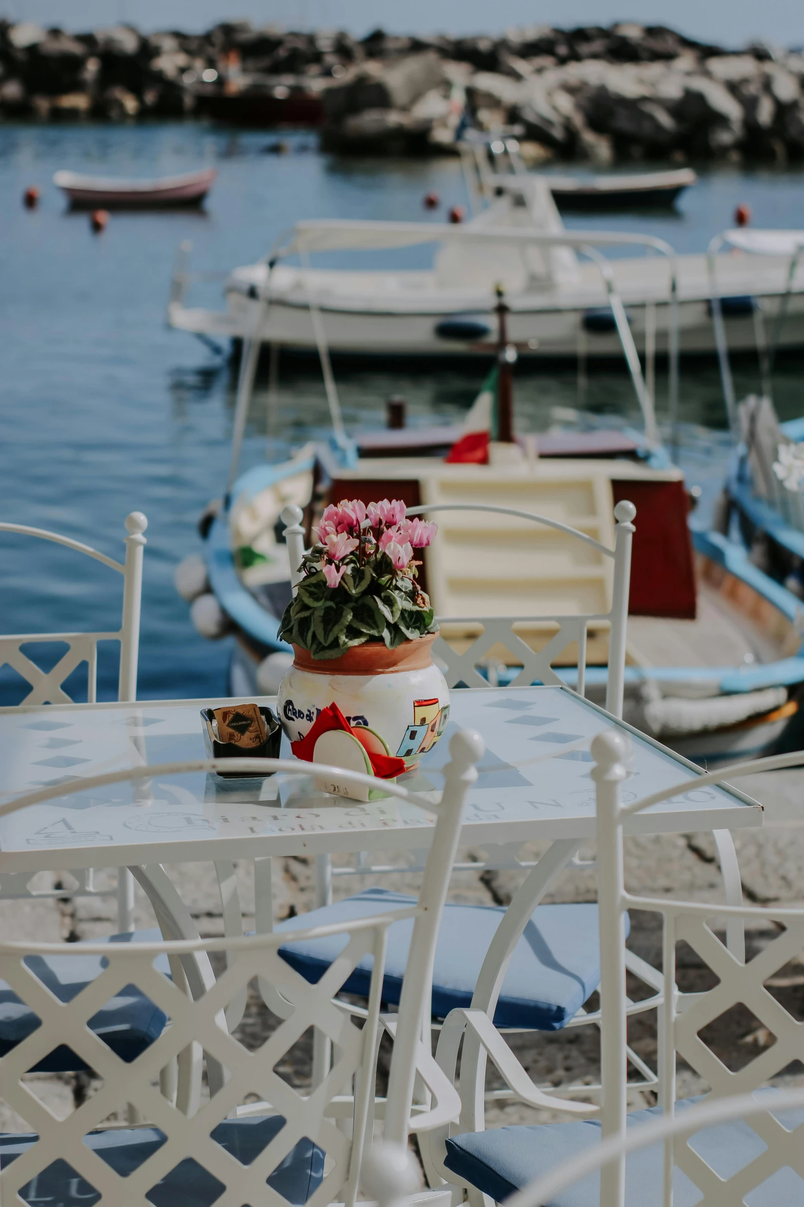 several tables and chairs with flowers on them in the water