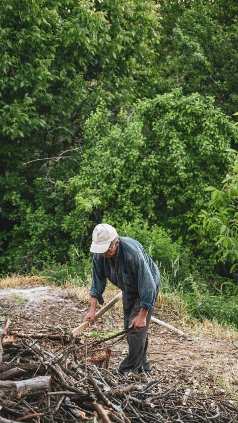 a man working on a pile of nches in the woods