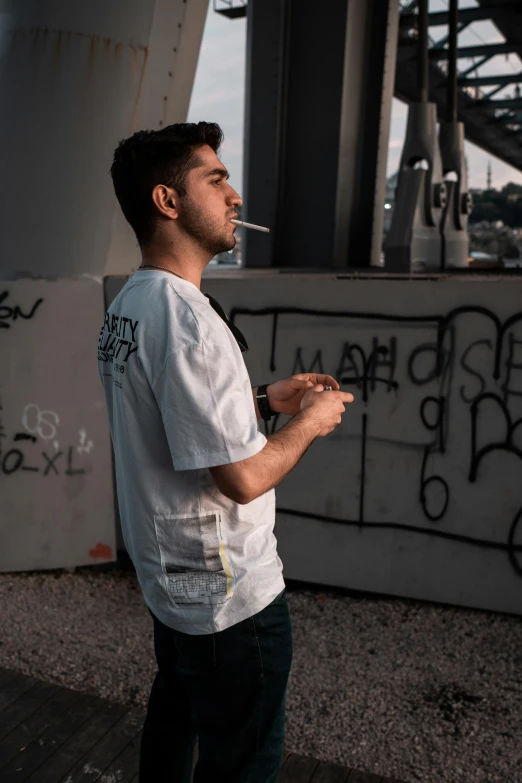 a man is standing with a cigarette in his mouth