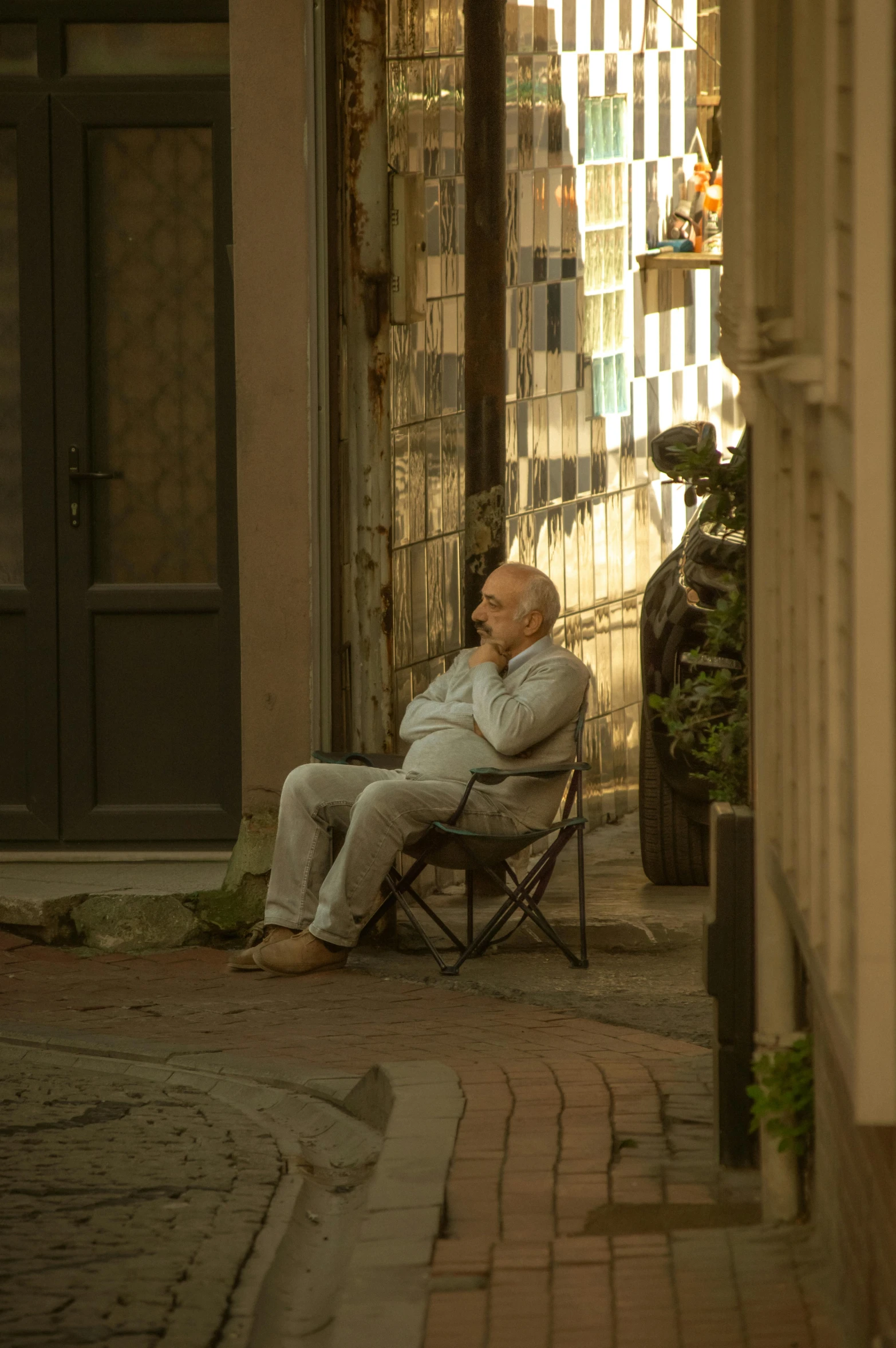 a man sitting on a chair with his feet up while wearing white clothes