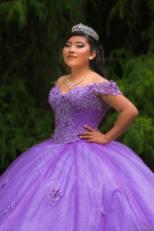 a woman in a princess purple dress poses with her hand on her hip