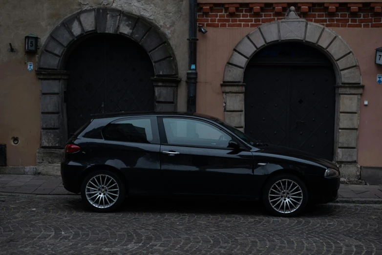 black car parked in front of doorways with no door handles