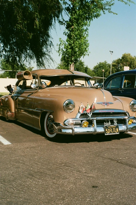 a classic car is parked on the street next to another classic car