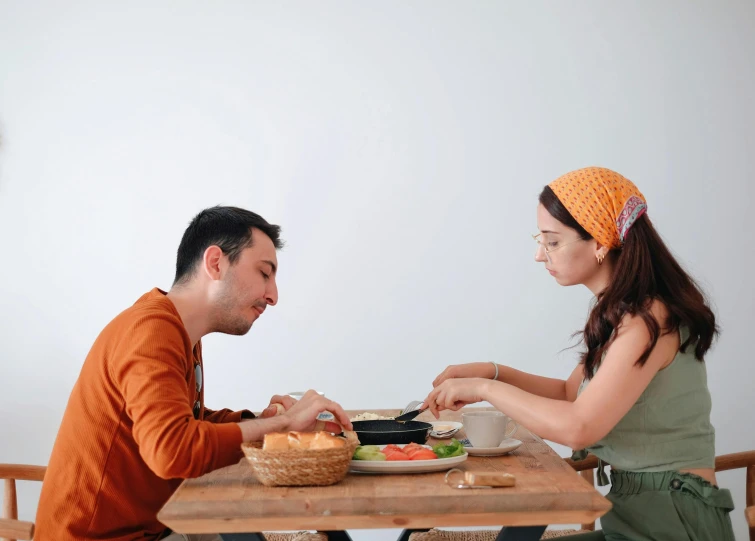 a man and woman are eating at a table