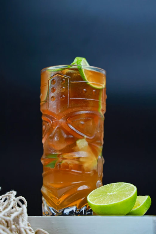 a glass of beverage with lime on the rim and ice