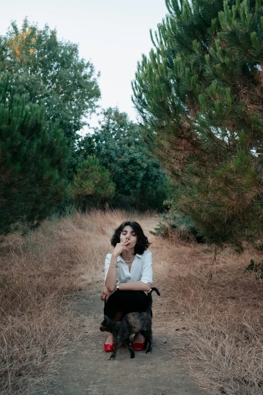 a woman and her dog sit in the middle of the field