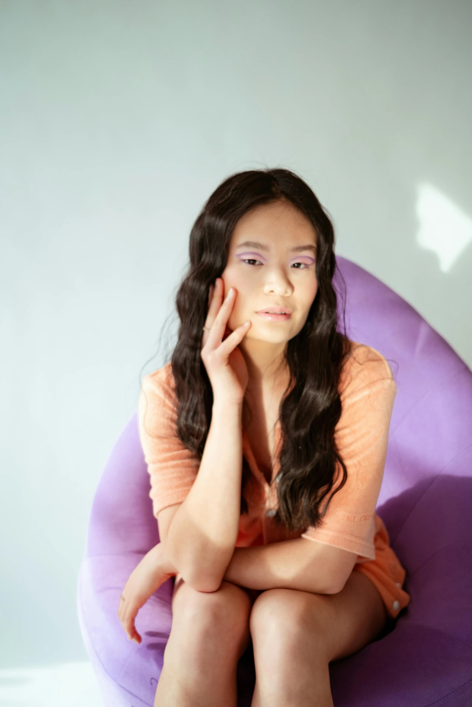 a girl sitting on a big chair with her chin propped up