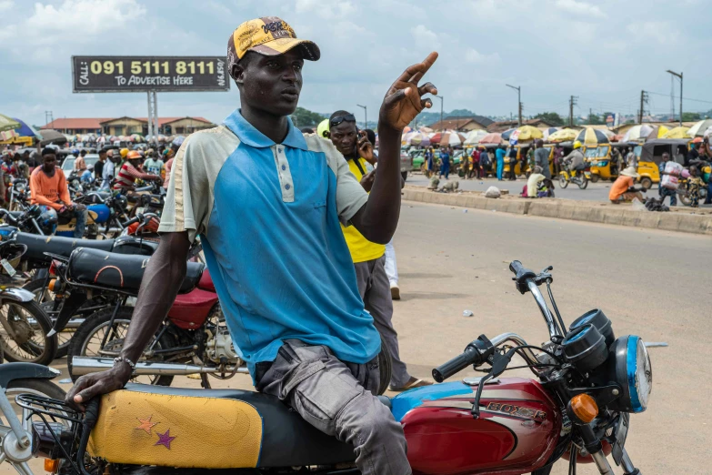 a man sitting on a motorcycle waving at the camera