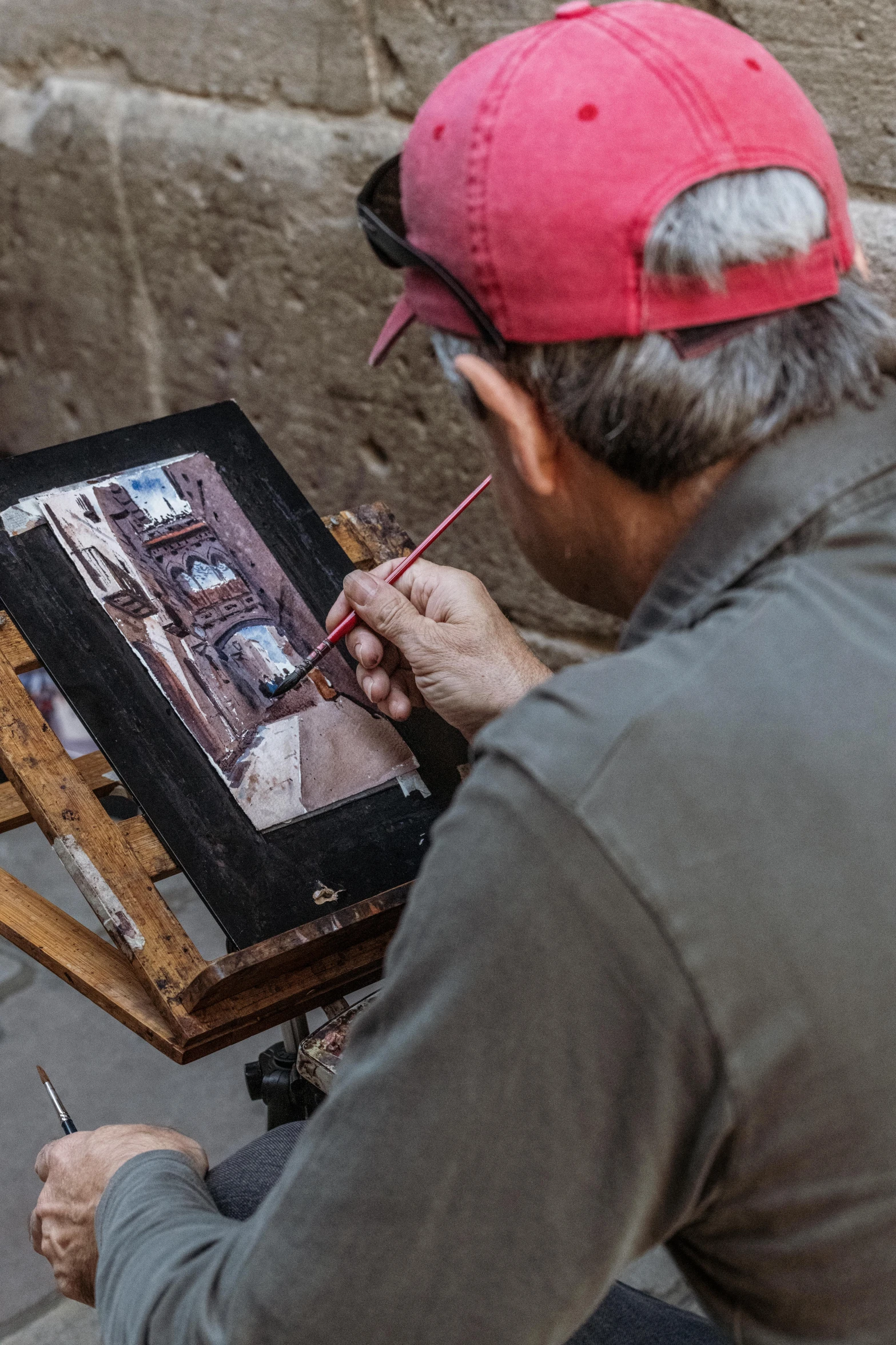 a person is painting a city scene on an easel