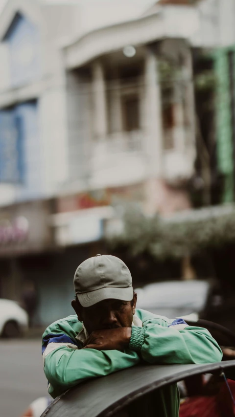 a man in a cap sitting on top of a car