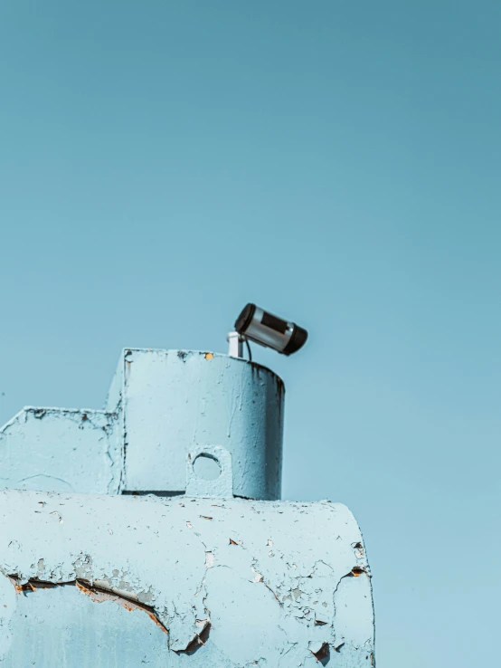 a small, old, rusted looking object is sitting on a wall