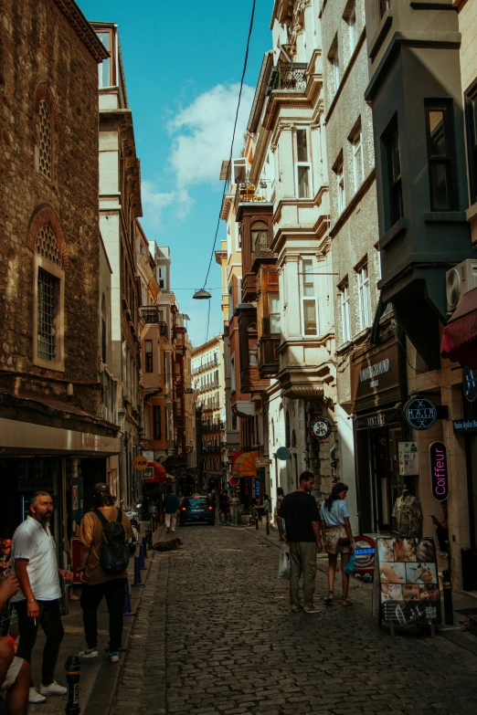 the sidewalk area is busy with people, shopping, and sitting