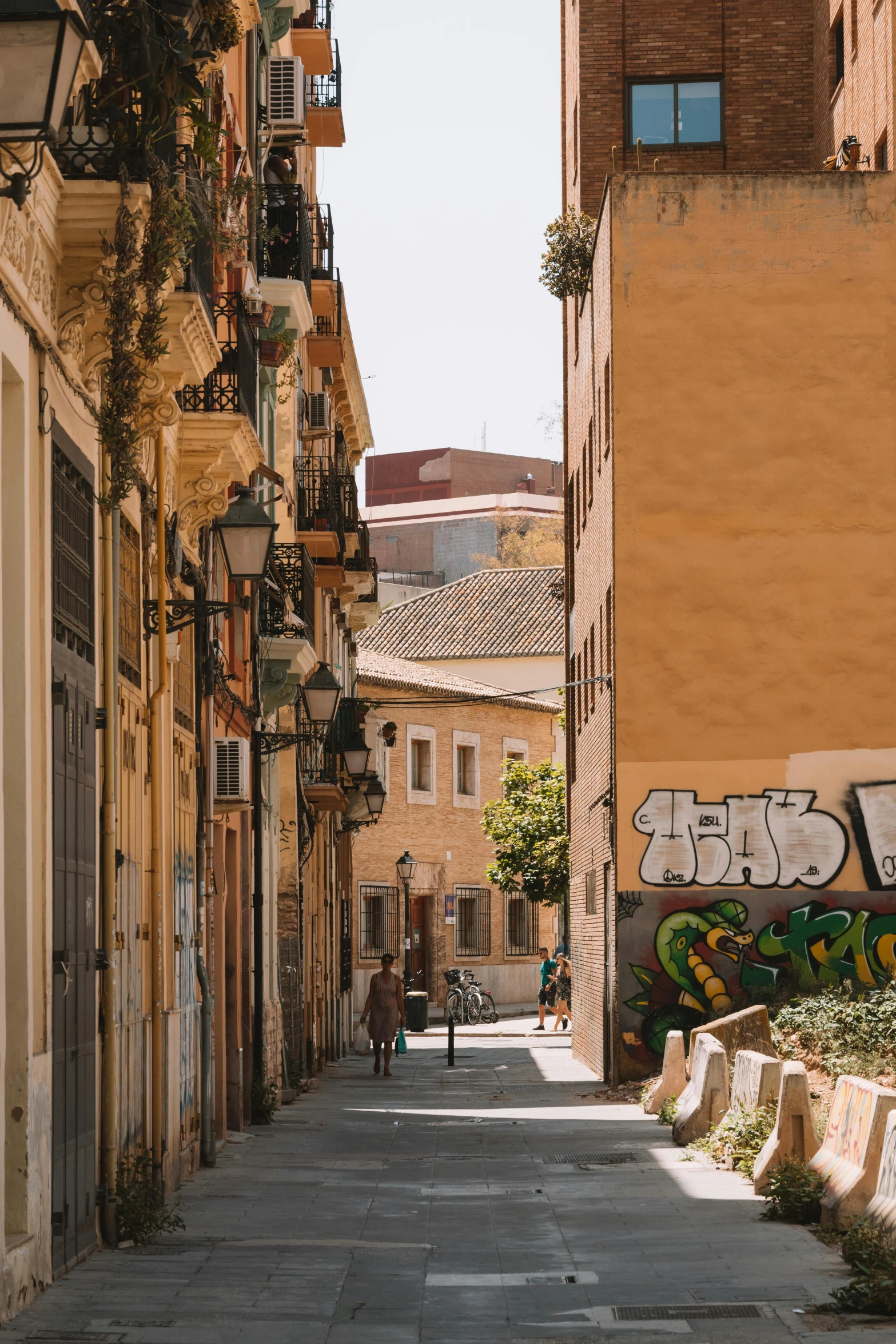 a city street is lined with graffiti and buildings