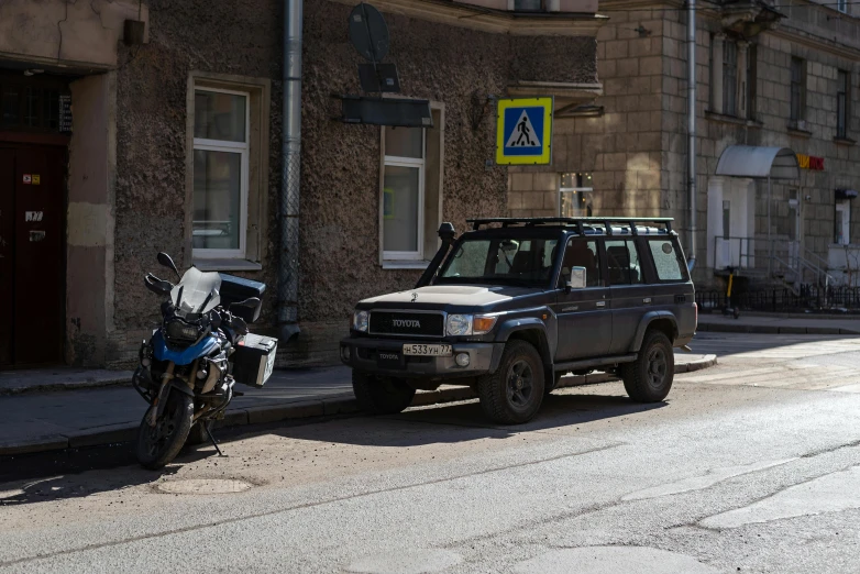 a parked motorcycle is next to a car on a street