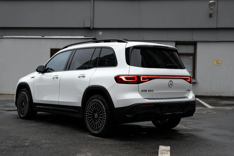 a white bmw suv parked in front of a warehouse