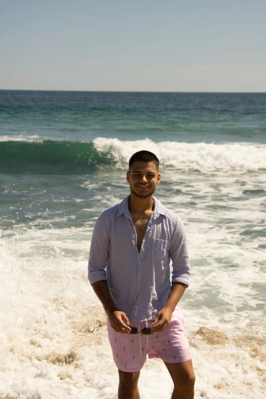 a man poses for a picture at the beach