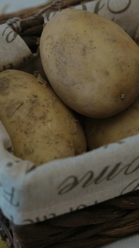 a basket filled with potatoes with writing on it