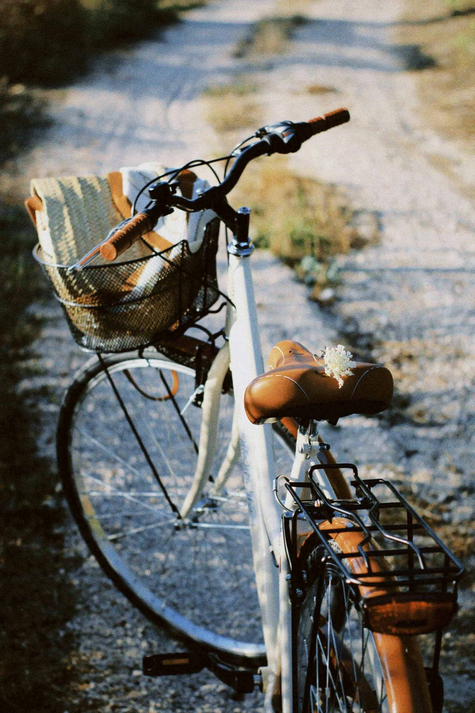 a bike is leaning on the edge of a gravel road