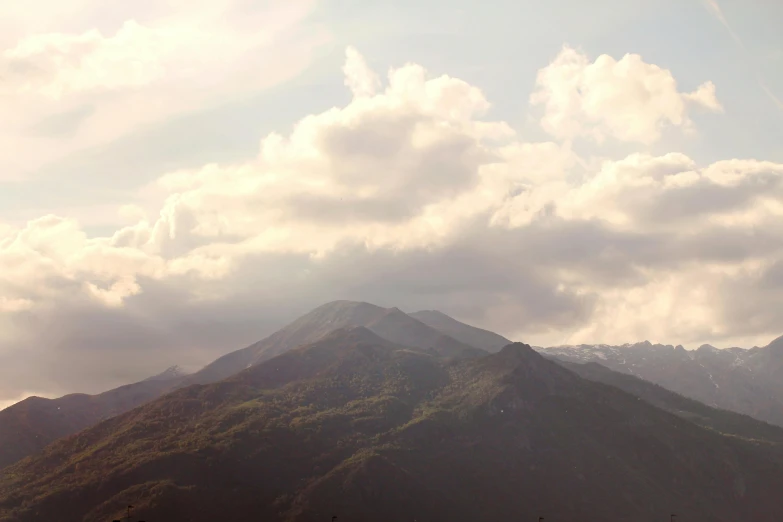 a large mountain peak under a cloudy blue sky